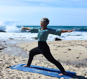 Frau macht Yoga am Strand von Elba
